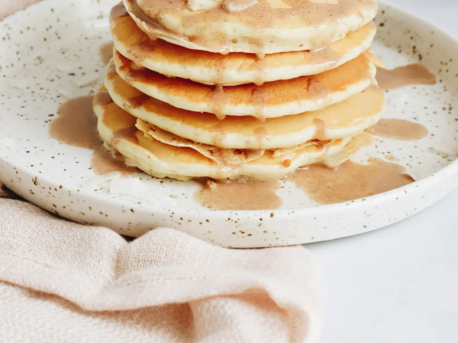 Tall stack of fluffy protein pancakes with banana